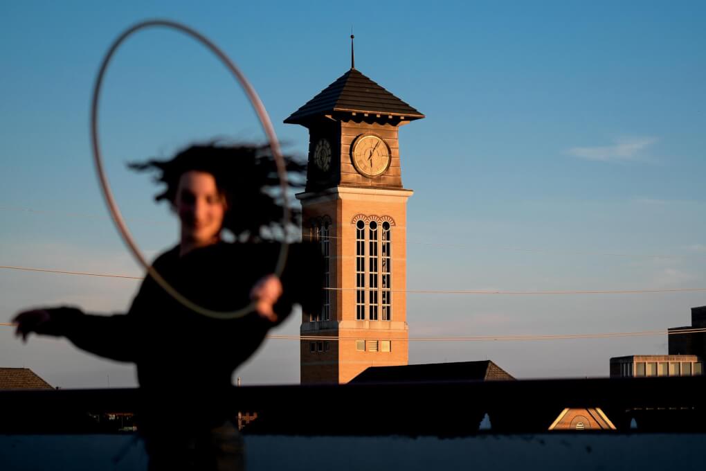 Student hula hoops in front of the Beckering Tower downtown